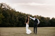 Bride with groom wearing satin sheath wedding dress.