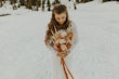 Bride holding Fall color bouquet with orange ribbon wearing long sleeved lacy wedding dress called Tina Dawn.