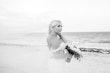 Bride stood by the shore with veil floating behind her.