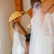 Bride Wearing Boho Sleeved Wedding Dress Called Drita By Maggie Sottero Looking In A Mirror