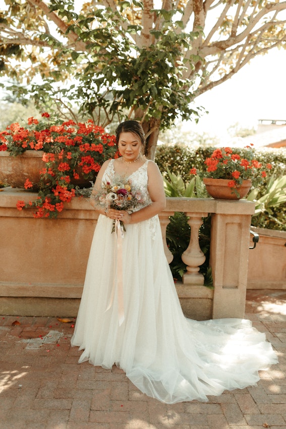 Bride wearing affordable A-Line floral motif wedding dress.