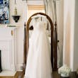Nisha by Maggie Sottero hanging over a mirror