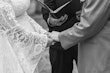 Bride wearing Bronson by Sottero and Midgley holding hands with her husband during their ceremony