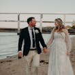 Bride Wearing Off-The-Shoulder Lace Wedding Dress Called Carson By Sottero And Midgley Walking On The Beach With Groom