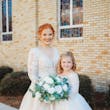 Bride Standing With Young Girl Wearing Similar White Gowns. Bride Wearing Illusion Sleeve A-line Wedding Dress Called Raphael By Maggie Sottero