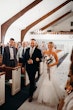 Father walking daughter down the aisle both with shy smiles.