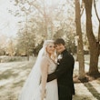 Groom Hugging Bride Wearing Bridal Dress Called Raelynn by Rebecca Ingram