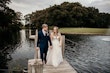 Bride wearing Stevie wedding gown by Maggie Sottero holding hands with her husband