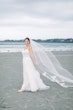 Bride Wearing Boho Sheath Wedding Dress Called Marisol By Rebecca Ingram On The Beach