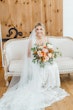 Bride wearing Albany wedding dress by Maggie Sottero sitting on a couch