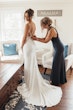 Bride Wearing Crepe And Lace Bridal Dress Called Dionne By Rebecca Ingram With Bridesmaid Helping Her Get Ready