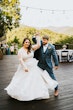 Bride Wearing Shimmery Princess Bridal Gown Called Tiffany By Maggie Sottero Dancing Outside With Groom