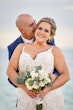 Groom Kissing Bride in Lovely Plus Size Fit-and-Flare Tulle Wedding Dress with Delicate Lace Motifs Accented with Beading Called Glorietta Lynette by Maggie Sottero