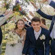 Bride wearing Charlotte by Rebecca Ingram going under a bridge of bridesmaids and groomsmen