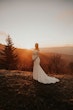 Bride Wearing Simple Long Sleeve Wedding Dress Called Bethany By Rebecca Ingram On A Hill