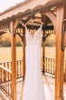 Crepe Sheath Wedding Dress Called Alda By Rebecca Ingram Hanging From A Gazebo