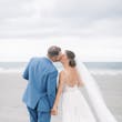 Bride Wearing Boho Sheath Wedding Dress Called Marisol By Rebecca Ingram Kissing Groom On The Beach