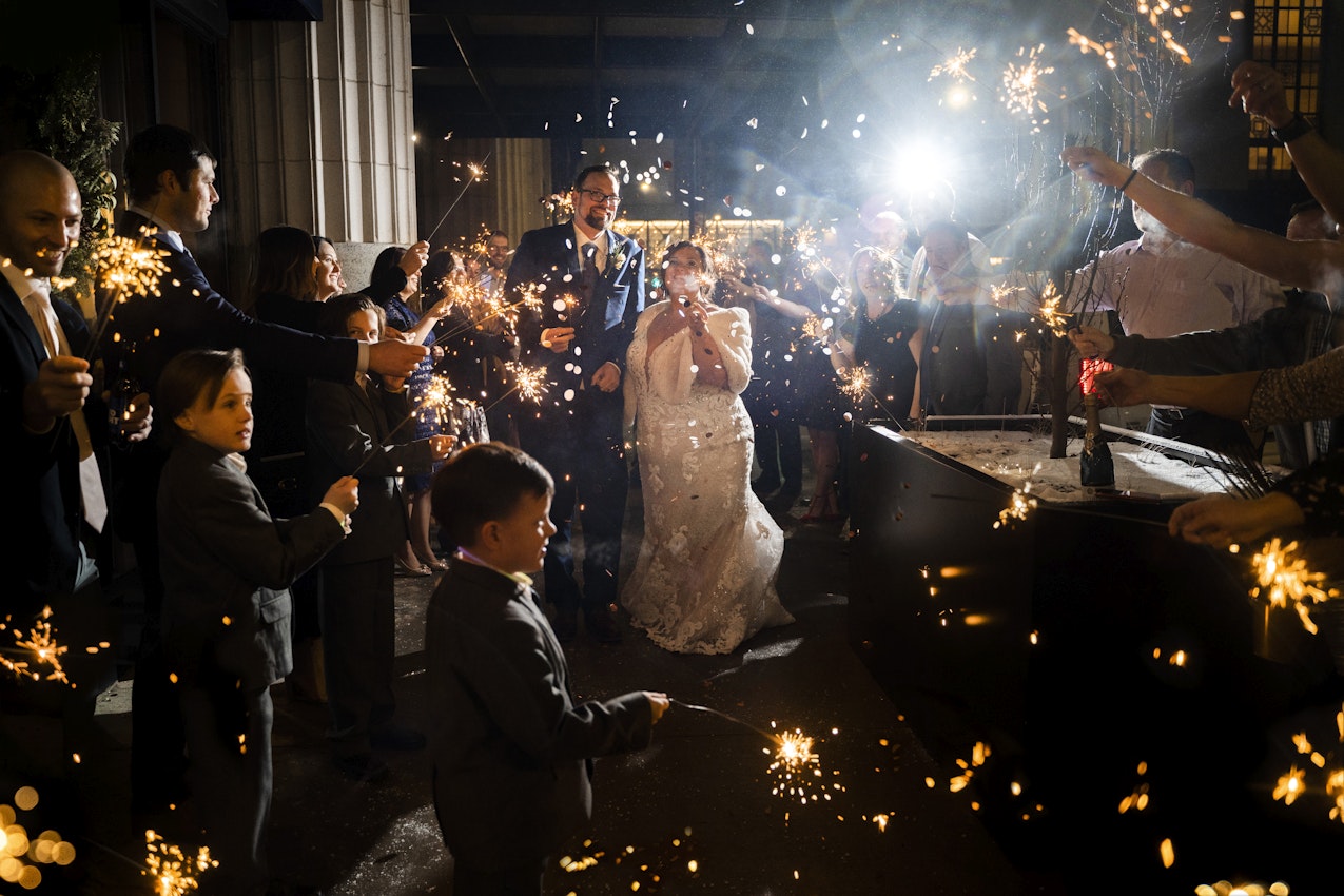 Bride and Groom Celebrating with Sparklers With Wedding Guests Wearing Wedding Dress Called Tuscany Marie by Maggie Sottero