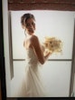 Bride holding all ivory bouquet looking over her shoulder.