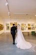 Bride wearing Mitchell Marie Vida by Maggie Sottero with her husband in a museum