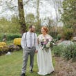 Bride Wearing Chiffon A-Line Wedding Dress Called Heather By Rebecca Ingram With Groom In A Garden