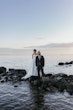 Bride Wearing Sexy Strapless Wedding Dress Called Zelda By Rebecca Ingram With Groom On A Lake