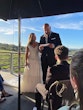 Bride wearing Darius wedding dress by Maggie Sottero watching her husband reading vows