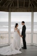 Bride wearing Frederique wedding gown by Maggie Sottero holding hands with groom