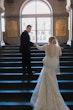 Bride wearing Riviera by Sottero and Midgley walking up stairs with her husband