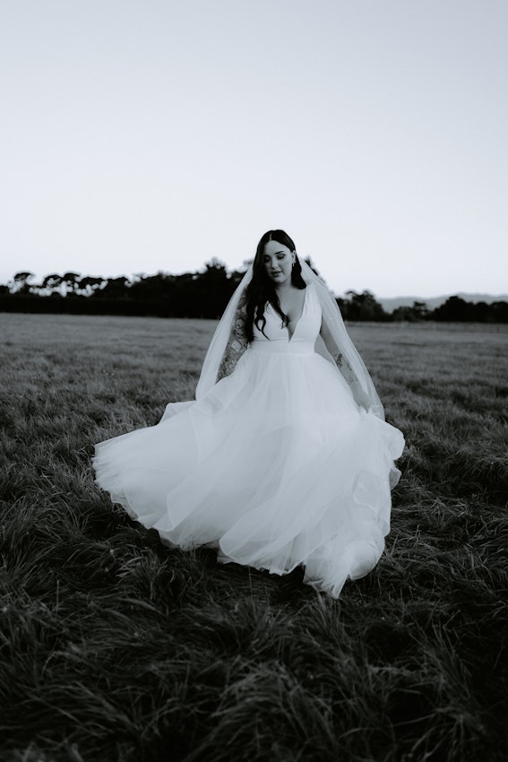 Real Bride wearing bright white modern ballgown wedding dress with ruffles called Fatima by Maggie Sottero.
