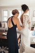 Bride Wearing Crepe And Lace Bridal Dress Called Dionne By Rebecca Ingram Getting Dressed