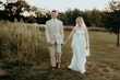 Bride wearing Albany wedding dress by Maggie Sottero walking with her husband