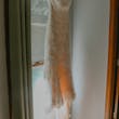 lace wedding dress called Drew hanging by the window.