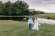 Groom and Bride Wearing Boho Wedding Dress Called Lorraine Dawn By Rebecca Ingram Walking Together