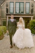 Bride wearing Laila wedding dress by Maggie Sottero walking with her husband