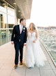 Bride wearing Hattie Lane Marie wedding dress by Rebecca Ingram walking with her groom