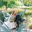 Bride Wearing Sexy Lace Wedding Dress Called Lennon By Maggie Sottero Kissing Groom On A Butterfly Bench
