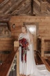 Bride In Chiffon Wedding Dress Called Tasha By Rebecca Ingram With Red And Blue Rose Bouquet