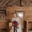 Bride In Chiffon Wedding Dress Called Tasha By Rebecca Ingram With Red And Blue Rose Bouquet