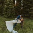 Groom dipping bride in the outdoors. Bride wearing boots with her wedding dress called Tina Dawn.