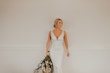 Bride wearing simple sheath wedding dress with V-neck.