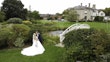 Bride In Lace A-Line Wedding Dress Called Taylor By Maggie Sottero With Long Veil And Groom