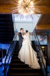 Bride wearing Derrick by Maggie Sottero on the stairs with her husband