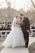 Real Bride In Ruffled Wedding Dress Called Fatima By Maggie Sottero With Groom During Ceremony