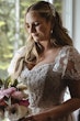 Bride Wearing Lace Aline Wedding Dress Called Harlem By Maggie Sottero Looking At Her Bouquet