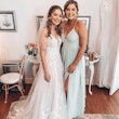 Bride with bridesmaid wearing affordable floral ballgown wedding dress.