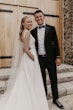 Bride wearing Paxton by Maggie Sottero smiling with her husband