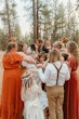 Bride Wearing Lace Wedding Dress Called Ladonna By Maggie Sottero Kissing Groom With Family Celebrating