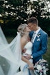Bride and groom kissing while the brides veil floats in the breeze.