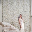 Bride wearing Bailey by Sottero and Midgley in front of a flower wall